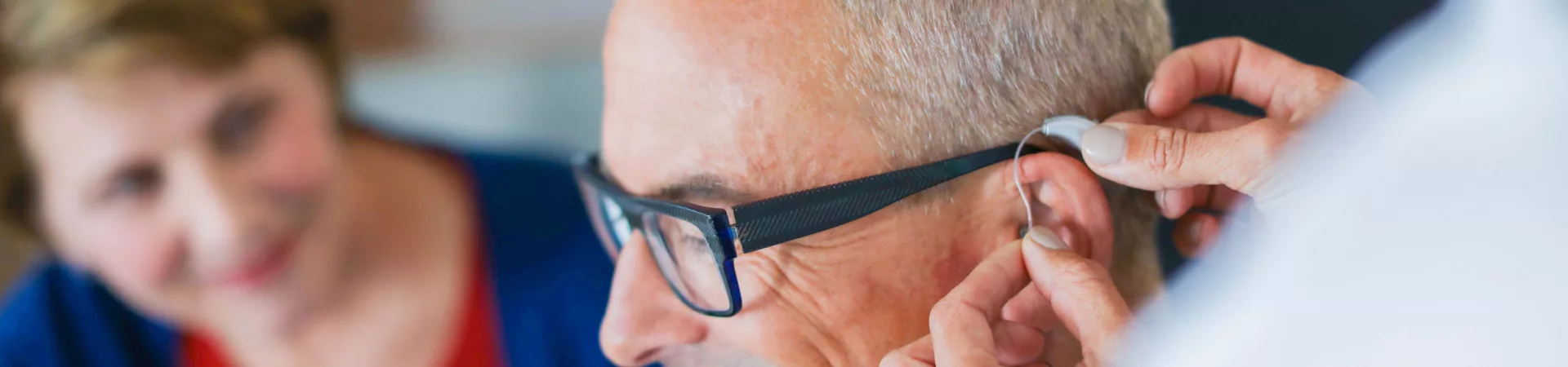 older man is fitted with first hearing aid