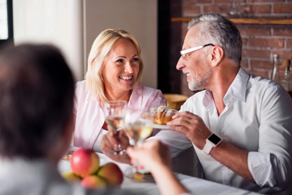a man and woman talk over a crowded brunch table