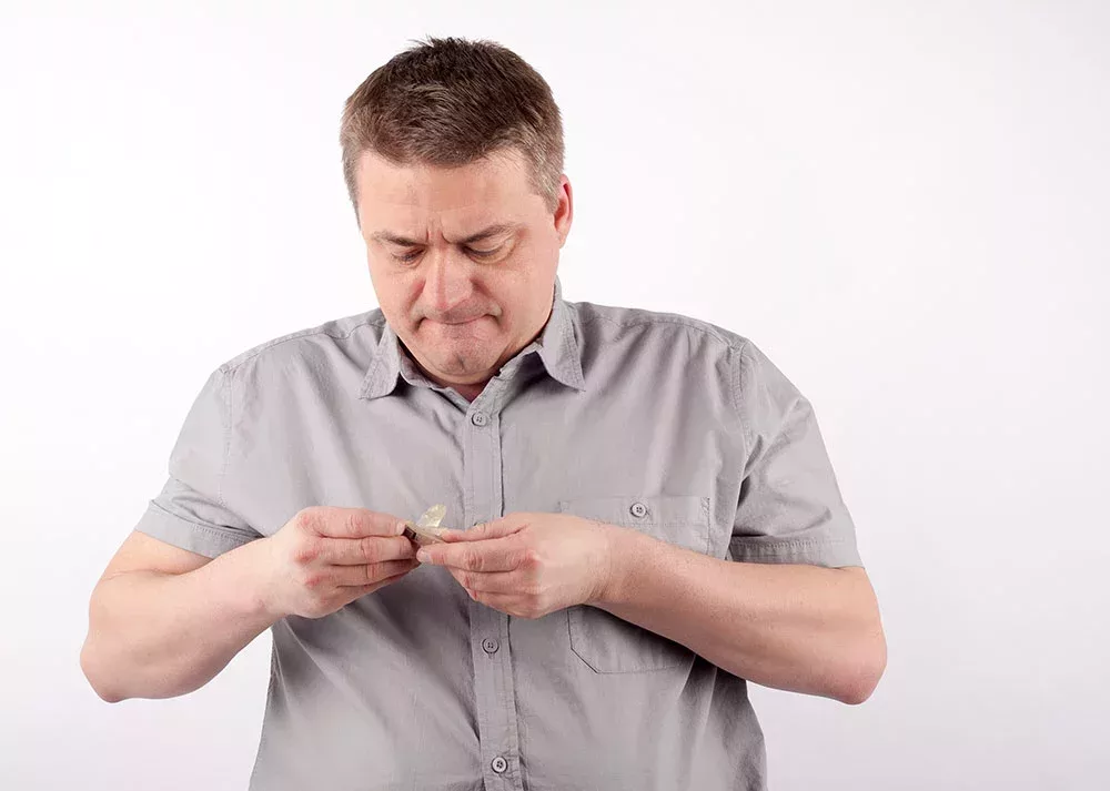 man attempting to repair his hearing aid